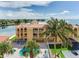 Exterior of condo building with waterfront views, a pool, and lounge chairs at 5353 Gulf Blvd # A402, St Pete Beach, FL 33706