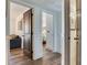 Hallway view to living spaces, with wood-look tile flooring and neutral wall paint with contrasting dark-stained doors at 5353 Gulf Blvd # A402, St Pete Beach, FL 33706