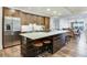 Modern kitchen with stainless steel appliances, island with seating, and wood cabinetry at 5353 Gulf Blvd # A402, St Pete Beach, FL 33706
