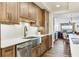 Well-lit kitchen featuring wood cabinets, stainless steel appliances, and a large basin sink at 5353 Gulf Blvd # A402, St Pete Beach, FL 33706