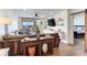 View of the living room with wood floors, leather sofa, large screen tv, and access to the bedroom and exterior patio at 5353 Gulf Blvd # A402, St Pete Beach, FL 33706