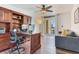 Comfortable home office with hardwood floors, ceiling fan, balcony access, and custom built-in shelving at 5353 Gulf Blvd # A402, St Pete Beach, FL 33706