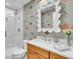Stylish bathroom featuring shower, wood vanity, quartz countertop and decorative wallpaper at 610 Pinellas Bayway S # 5202, Tierra Verde, FL 33715
