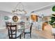 Dining area with modern chandelier, glass table, bar seating and view into kitchen at 610 Pinellas Bayway S # 5202, Tierra Verde, FL 33715