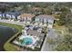 Aerial view showcases community pool, a pond, and two-story townhomes with individual driveways, blending suburban living with amenities at 6825 Citrus Creek Ln, Tampa, FL 33625