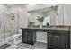 Bathroom with double sink vanity featuring granite counters, modern fixtures and a glass enclosed shower at 6825 Citrus Creek Ln, Tampa, FL 33625