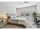 Cozy bedroom featuring a tufted headboard, ample natural light, and ceiling fan at 6825 Citrus Creek Ln, Tampa, FL 33625