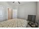 Bedroom with a patterned bedspread, TV, window and ensuite access, offering comfort and convenience at 6825 Citrus Creek Ln, Tampa, FL 33625
