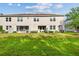 Rear view of the townhome featuring a lush lawn, patios, and privacy fences at 6825 Citrus Creek Ln, Tampa, FL 33625
