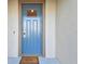 Inviting blue front door with a 'Welcome' mat sits in front of the home at 6825 Citrus Creek Ln, Tampa, FL 33625