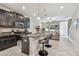 Open-concept kitchen boasts dark cabinetry, granite countertops, stainless appliances, and a breakfast bar with seating at 6825 Citrus Creek Ln, Tampa, FL 33625