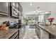 Contemporary kitchen with granite countertops, stainless steel appliances, and an open view to the living area at 6825 Citrus Creek Ln, Tampa, FL 33625