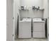 Well-equipped laundry room with washer, dryer, and storage shelf at 6825 Citrus Creek Ln, Tampa, FL 33625