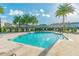 A turquoise community pool surrounded by palm trees and lounge chairs, offering a refreshing and tropical oasis for residents at 6825 Citrus Creek Ln, Tampa, FL 33625