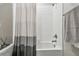Well-lit white tiled shower with contemporary fixtures and a stylish shower curtain at 6825 Citrus Creek Ln, Tampa, FL 33625