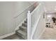 Carpeted staircase with white railings leading to a dining area at 6825 Citrus Creek Ln, Tampa, FL 33625