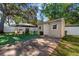 This backyard features a versatile outdoor area with dining and grilling spaces, set against a charming shed at 7003 Yule Ln, Tampa, FL 33637