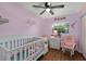 Charming Bedroom features a white crib, rocking chair, and pink decor for a cozy, welcoming space at 7003 Yule Ln, Tampa, FL 33637