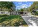 Charming single-story home boasts a manicured lawn and an inviting driveway, enhanced by mature trees and landscaping at 7003 Yule Ln, Tampa, FL 33637
