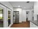 Bright kitchen area with stainless steel refrigerator and white cabinets, flowing into the adjacent dining area at 7003 Yule Ln, Tampa, FL 33637