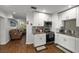 Well-lit kitchen featuring white cabinets, granite countertops, stainless steel appliances, and wood-look floors at 7003 Yule Ln, Tampa, FL 33637