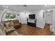 Comfortable living room showcasing hardwood floors, a plush sofa, and a modern entertainment center at 7003 Yule Ln, Tampa, FL 33637