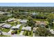 Aerial shot showcasing homes, lush greenery, and a serene lake in the background at 709 Pinewood Dr, Dunedin, FL 34698