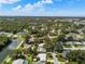 Expansive aerial view of the neighborhood featuring lush greenery, a pond, and single Gathering homes at 709 Pinewood Dr, Dunedin, FL 34698