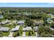 An aerial view of homes surrounding a picturesque lake amidst lush trees at 709 Pinewood Dr, Dunedin, FL 34698