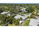 Aerial view of a home surrounded by lush greenery in a quiet residential neighborhood at 709 Pinewood Dr, Dunedin, FL 34698