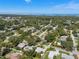 Expansive aerial view of the neighborhood featuring lush greenery, a skyline, and single Gathering homes at 709 Pinewood Dr, Dunedin, FL 34698