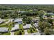 An aerial view of neighborhood homes near a tranquil lake surrounded by green trees at 709 Pinewood Dr, Dunedin, FL 34698