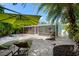 Spacious backyard with travertine pavers, lounge chairs, lush landscaping, and outdoor cooking area at 709 Pinewood Dr, Dunedin, FL 34698