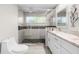 Modern bathroom featuring a glass-enclosed shower with a window and a marble countertop vanity at 709 Pinewood Dr, Dunedin, FL 34698