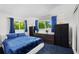 Cozy bedroom featuring bright windows, sleek furnishings, and vibrant blue accents at 709 Pinewood Dr, Dunedin, FL 34698