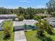 Charming, light blue single-story home with lush landscaping and a well-manicured lawn at 709 Pinewood Dr, Dunedin, FL 34698
