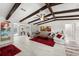 Bright living room with wood beam ceilings, stone accent wall, and a cozy seating area with vibrant artwork at 709 Pinewood Dr, Dunedin, FL 34698