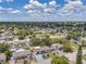 Expansive aerial view showcases a quaint neighborhood with mature trees and blue skies at 8045 Colton Dr, Port Richey, FL 34668