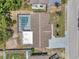 Aerial view of backyard featuring screened-in pool, fenced yard, mature trees, and a well-maintained roof at 8045 Colton Dr, Port Richey, FL 34668