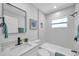 Modern bathroom featuring sleek fixtures, white tiling, and a shower-tub combo at 8045 Colton Dr, Port Richey, FL 34668