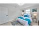 Serene bedroom featuring white walls, white bedding with blue accents, and ample natural light at 8045 Colton Dr, Port Richey, FL 34668
