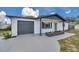 View of the front exterior featuring a gray two-car garage, gray roof, and a concrete driveway at 8045 Colton Dr, Port Richey, FL 34668