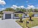 Charming home featuring a well-maintained yard, fresh landscaping, and a freshly painted driveway at 8045 Colton Dr, Port Richey, FL 34668