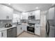 Well-lit kitchen featuring stainless steel appliances, white cabinets, and modern backsplash at 8045 Colton Dr, Port Richey, FL 34668