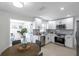 Kitchen with stainless steel appliances, white cabinets, and modern backsplash open to dining at 8045 Colton Dr, Port Richey, FL 34668