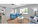 Sunlit living room with stylish blue chairs, front door, and a gray sofa at 8045 Colton Dr, Port Richey, FL 34668