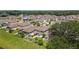 Aerial view of homes, manicured lawns, lush greenery, and a backyard with a pergola in a quiet neighborhood at 8050 Praise Dr, Tampa, FL 33625