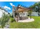Well-maintained backyard with patio, pergola, outdoor kitchen and beautifully manicured lawn at 8050 Praise Dr, Tampa, FL 33625