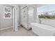Elegant bathroom featuring a freestanding tub, glass enclosed shower, and bright windows at 8050 Praise Dr, Tampa, FL 33625