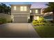 Charming two-story home showcasing a neat lawn, a palm tree, and inviting curb appeal at 8050 Praise Dr, Tampa, FL 33625